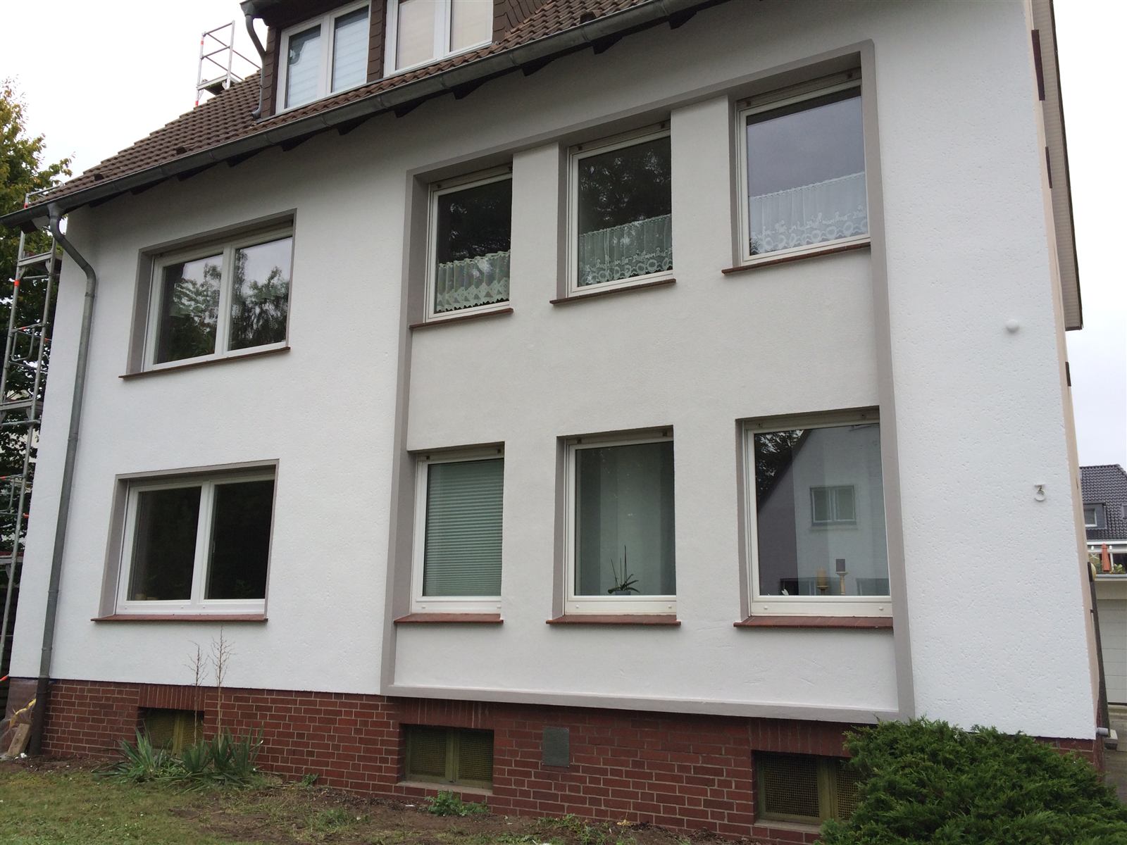 Fertig gestrichene weiße Hausfassade mit grauen Faschen