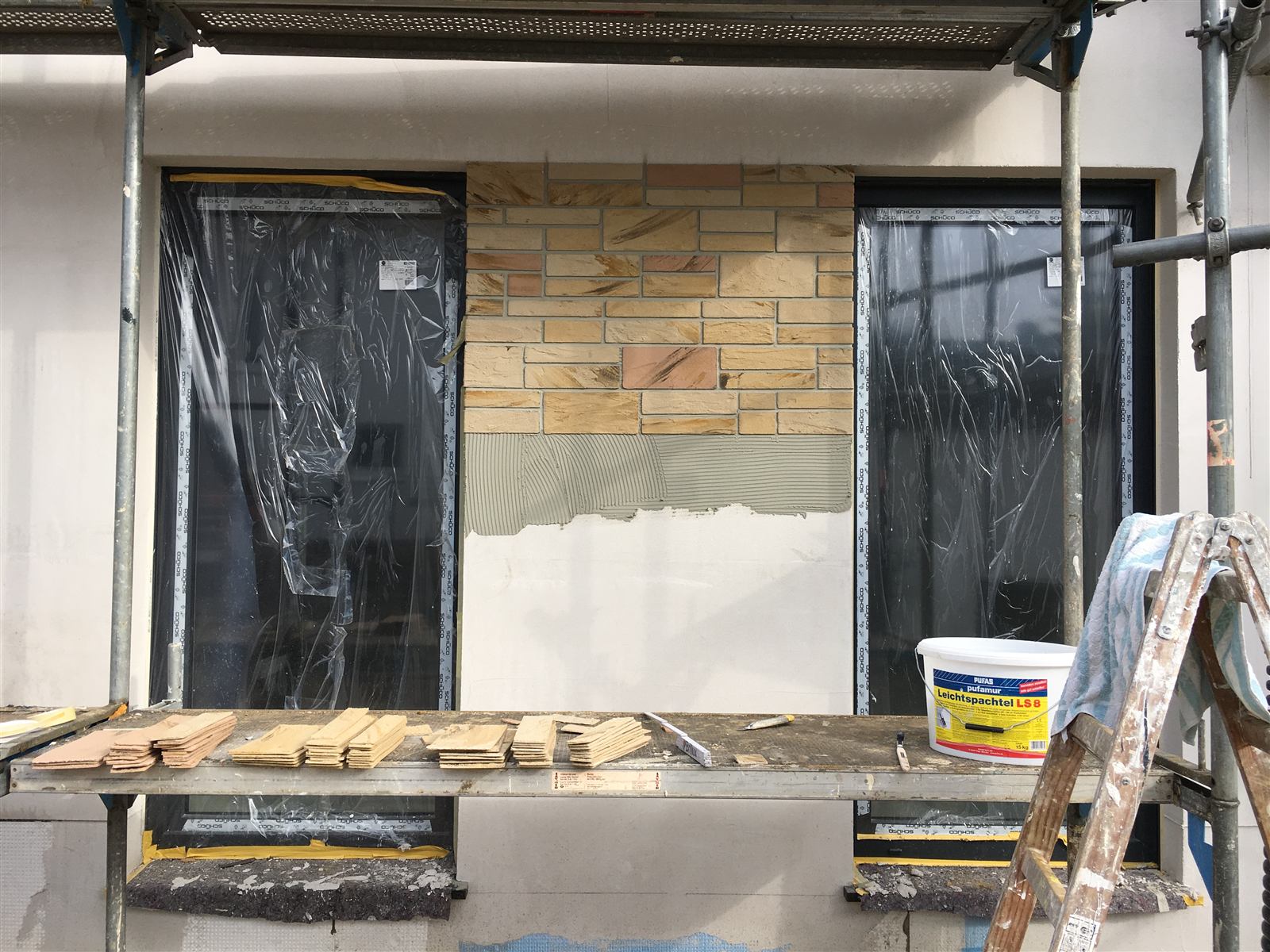 Verblendriemchen werden an einer Hausfassade angebracht