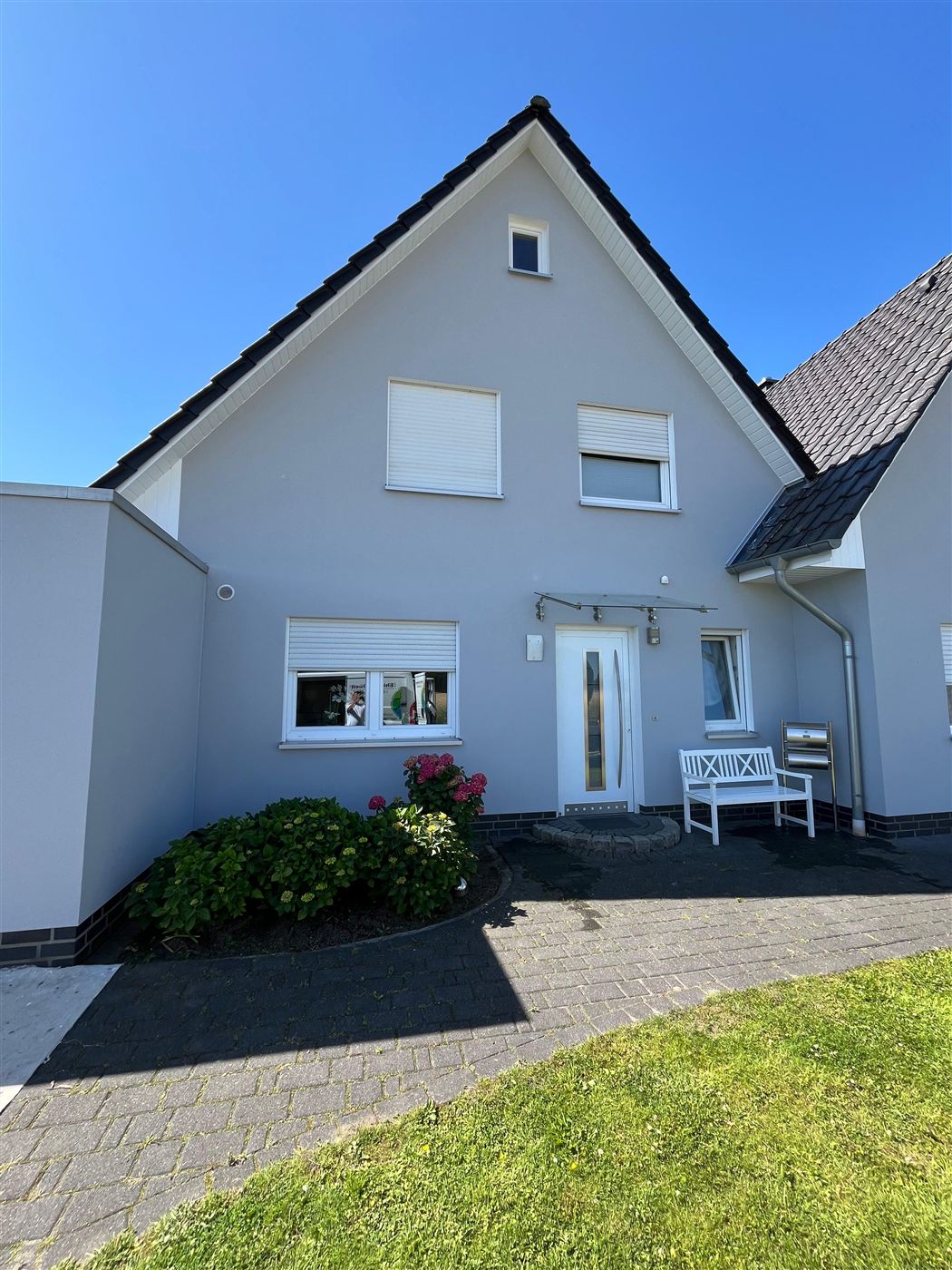 Dasselbe Haus nach Reinigung und Neuanstrich in hellem Grau
