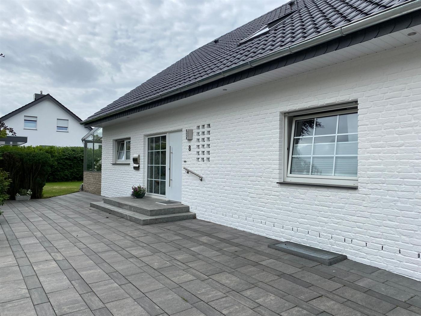 Dasselbe Haus nach dem Fassadenanstrich in strahlendem Weiß